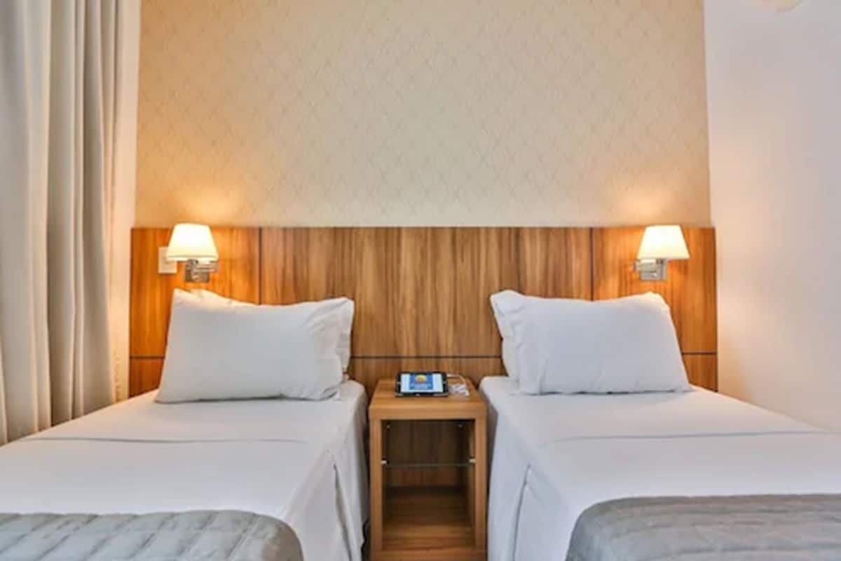 Minibar, escritorio, cortinas blackout y tabla de planchar con plancha