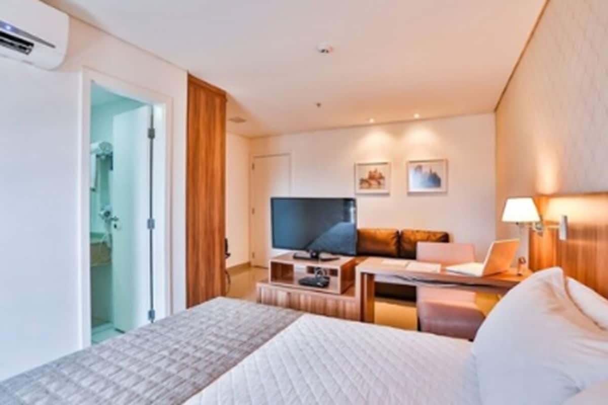 Minibar, escritorio, cortinas blackout y tabla de planchar con plancha