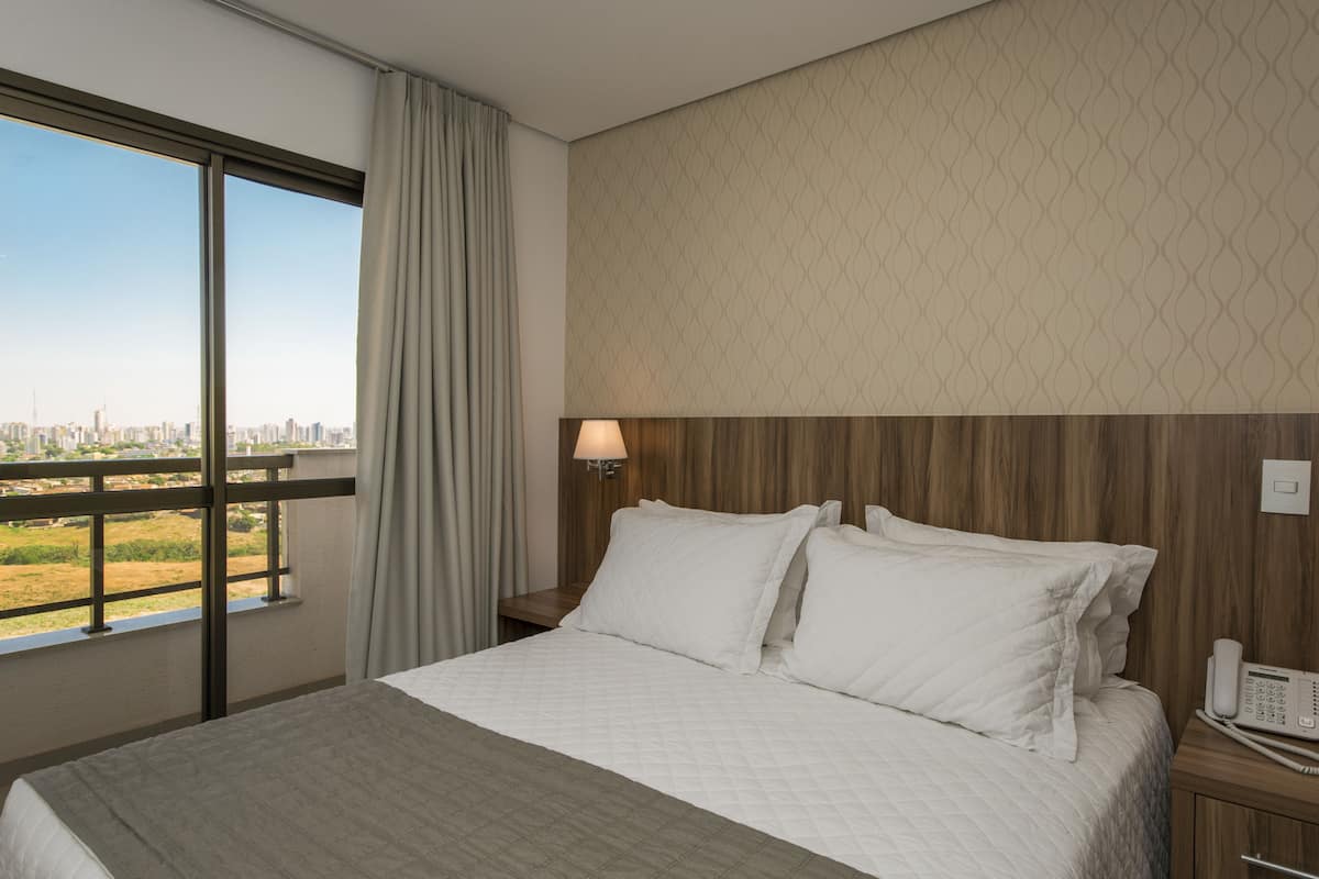 Minibar, escritorio, cortinas blackout y tabla de planchar con plancha