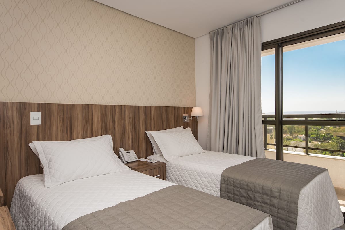 Minibar, escritorio, cortinas blackout y tabla de planchar con plancha