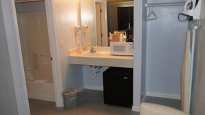 A small bathroom with a sink, mirror, and a microwave. - Sea Esta Motel II (Millsboro)