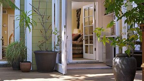 A covered outdoor area with potted plants and a wooden deck.