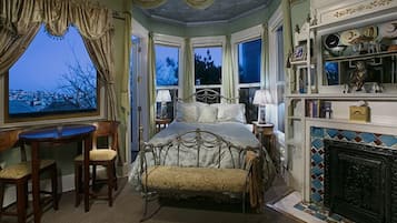 Een slaapkamer met een groot bed, een open haard en uitzicht.