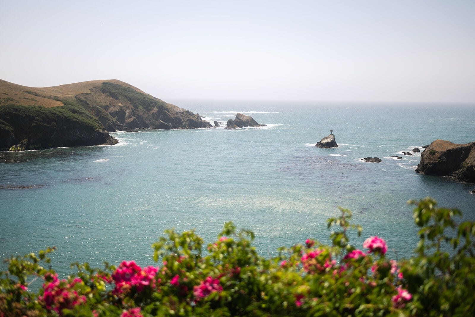 A coastal landscape with rocky outcrops and calm sea.
