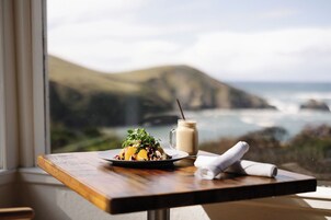 Una mesa con comida y bebida, con vistas a un paisaje costero.