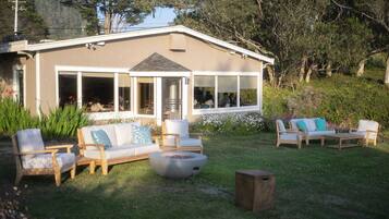 A house with a patio area featuring outdoor furniture and a fire pit.