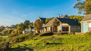 A residential area with houses on a hillside, featuring a wooden fence and lush greenery. - SCP Mendocino Coast Lodge  (Albion)