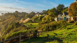 A hillside residential area with houses, a wooden fence, and lush greenery. - SCP Mendocino Coast Lodge  (Albion)