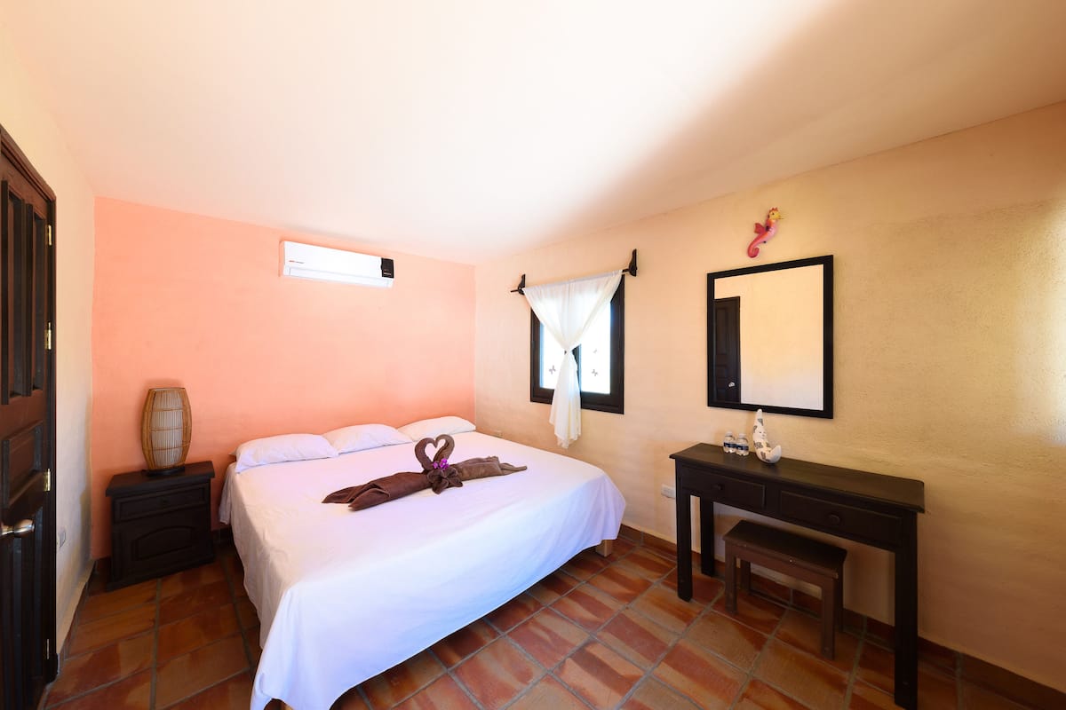 Une chambre à coucher avec un lit, une table de chevet et un bureau avec une chaise.