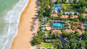 An aerial view of a resort with a beach, a swimming pool, and multiple bungalow-style buildings. - Khaolak Bay Front Resort (Takua Pa)