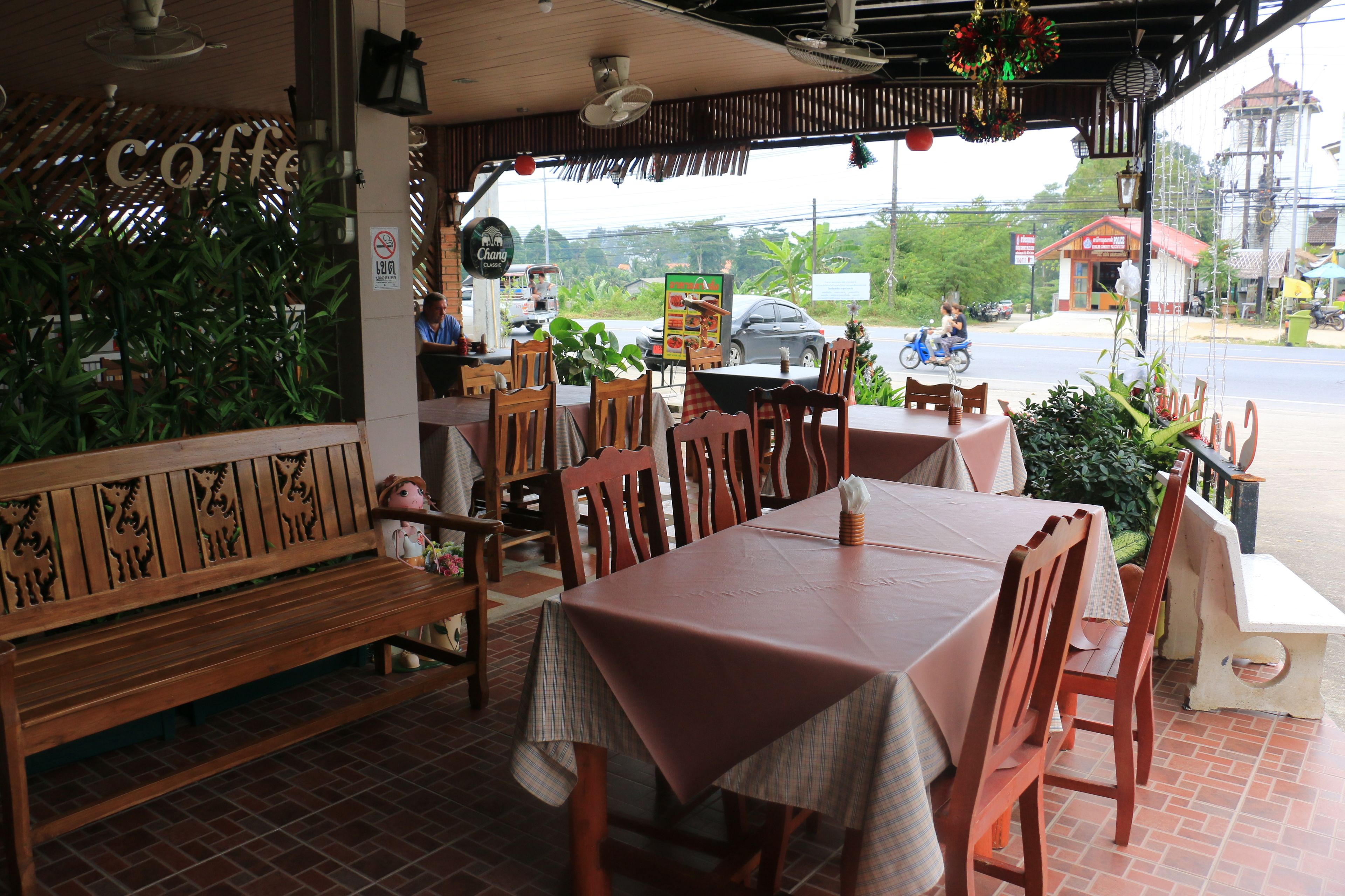 A restaurant with wooden furniture, a bench, and a table with a tablecloth.