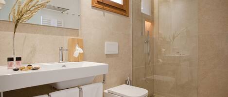 Un bagno moderno con doccia in vetro, lavandino bianco e water.