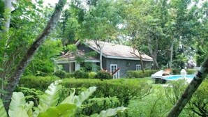 A house surrounded by lush greenery, with a swimming pool visible in the background. - The Bungalow at Pantiya Estate (Matugama)