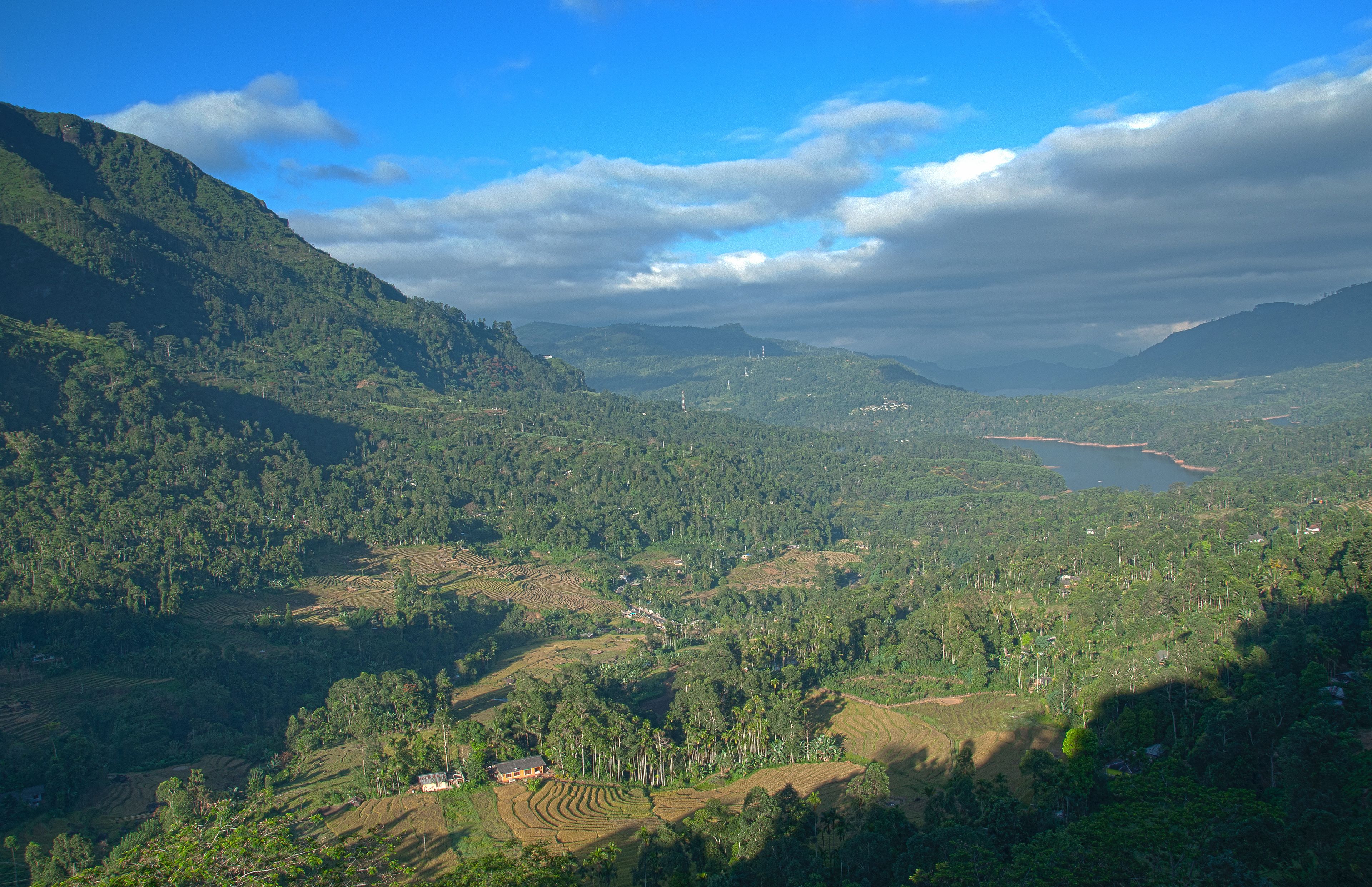A mountainous landscape with terraced fields and a small building.
