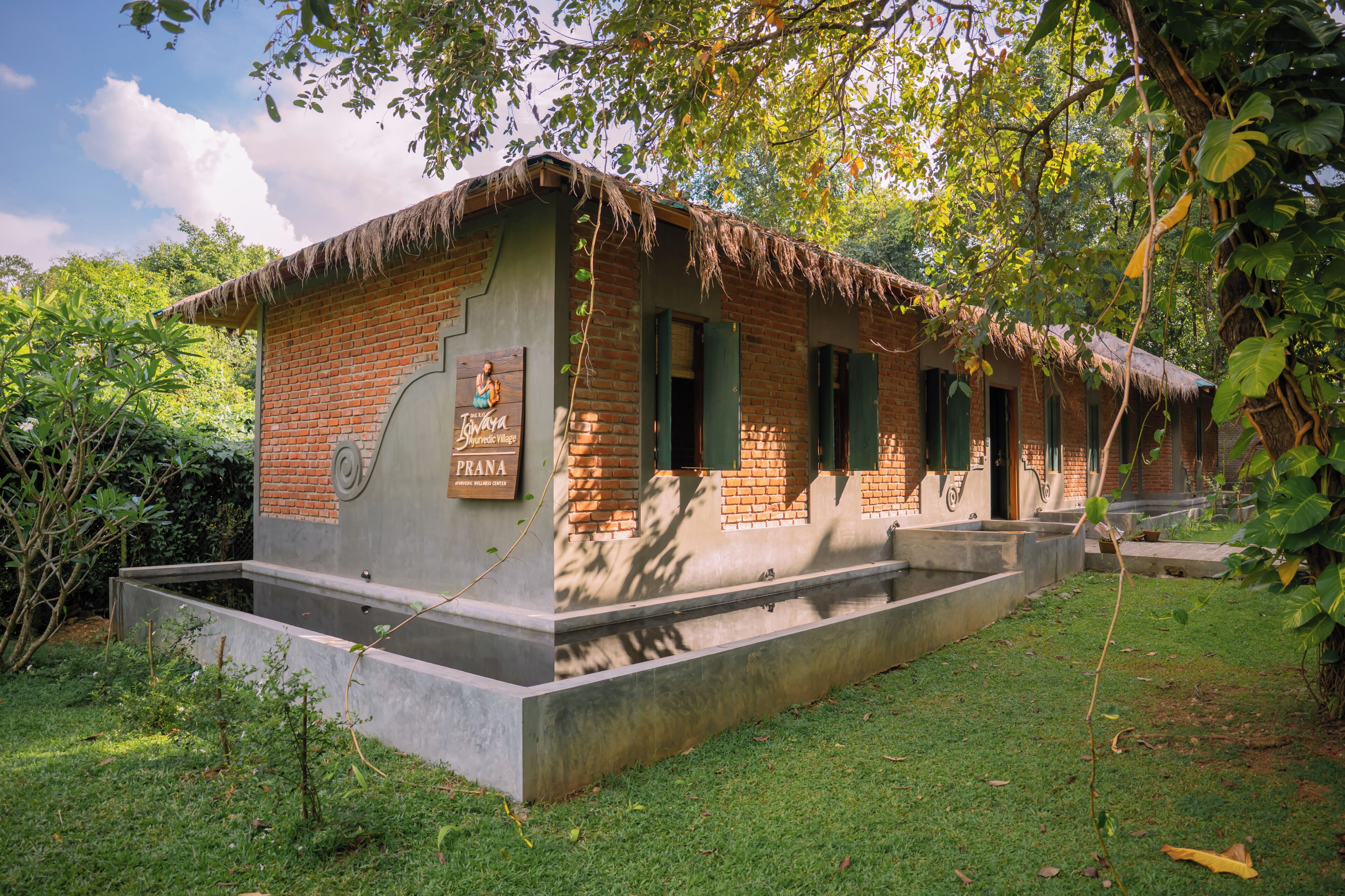 A brick building with a thatched roof, a concrete foundation, and a sign indicating it is a spa resort.