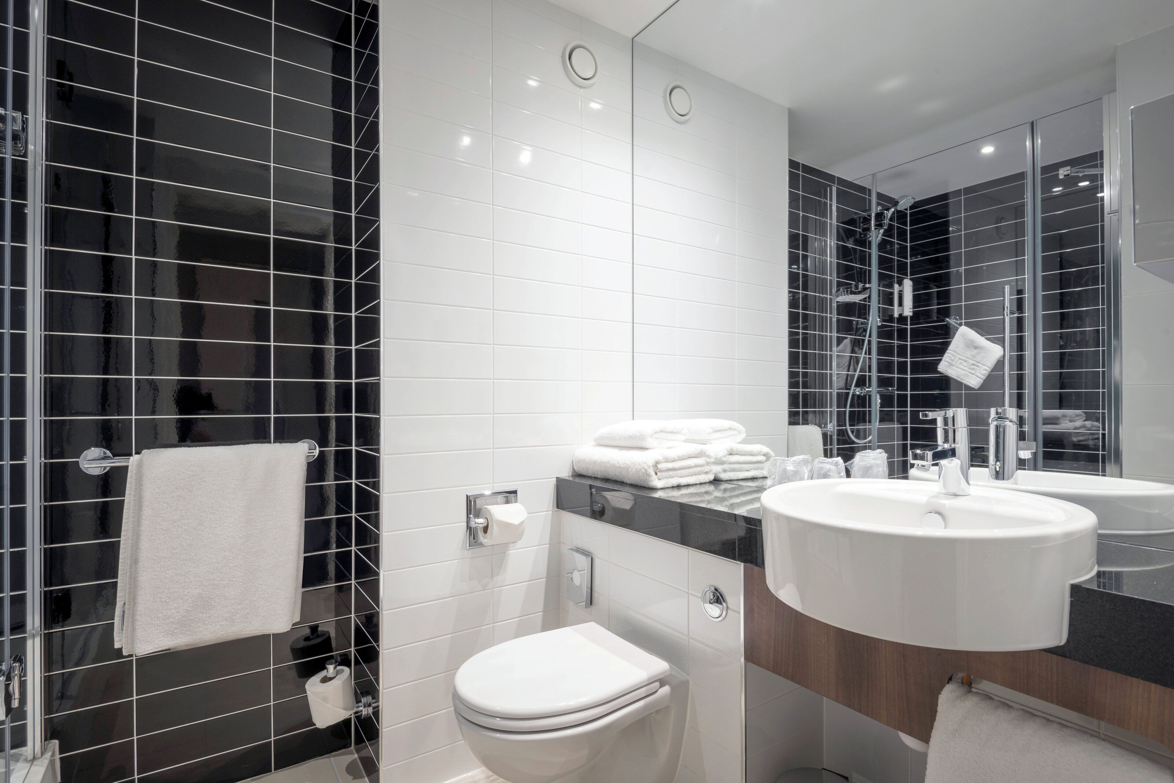 Ein modernes Badezimmer mit Toilette, Bidet und zwei Waschbecken.