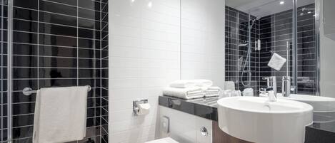 Uma casa de banho moderna com sanita, bidé e duas lavatórios.