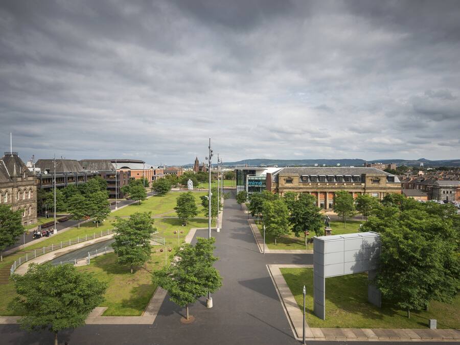 A campus with multiple buildings, a central open space, and a large parking area.