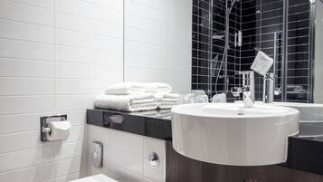 A modern bathroom with a toilet, sink, and mirror.