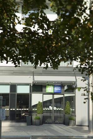 A Holiday Inn Express building with a glass entrance, potted plants, and a clear sign above the doors. - Holiday Inn Express Middlesbrough - Centre Square by IHG (Middlesbrough)