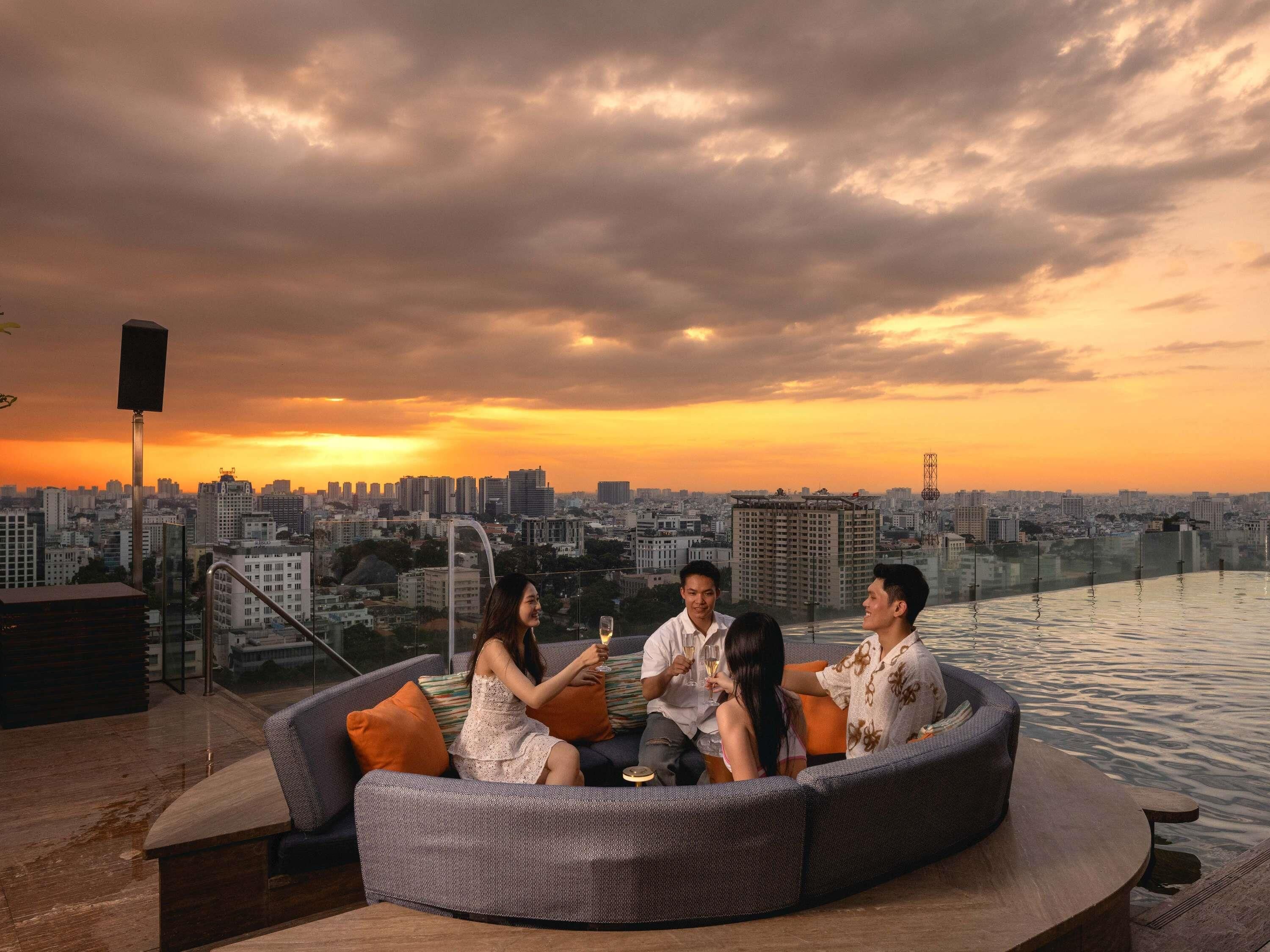 A rooftop lounge with a cityscape view at sunset.