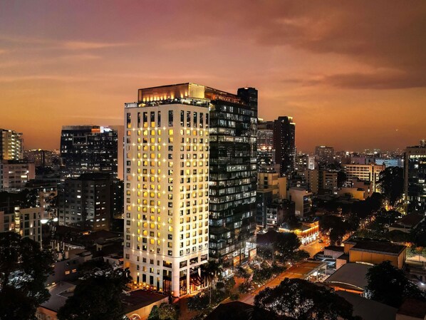 Un hotel de gran altura con varios pisos, una entrada destacada y un entorno urbano.
