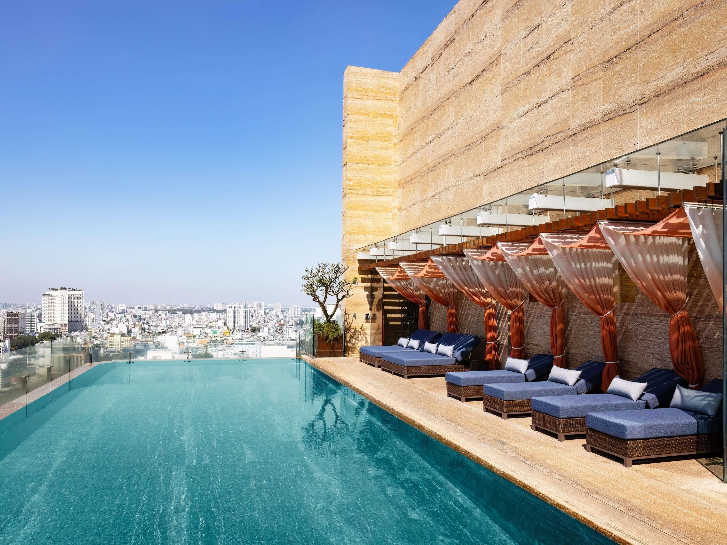 Una piscina al aire libre, sillones reclinables de piscina