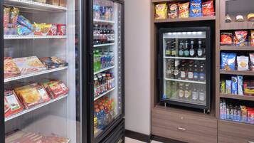 Vitrina refrigerada con diferentes alimentos y bebidas, como aperitivos, refrescos y salsas.