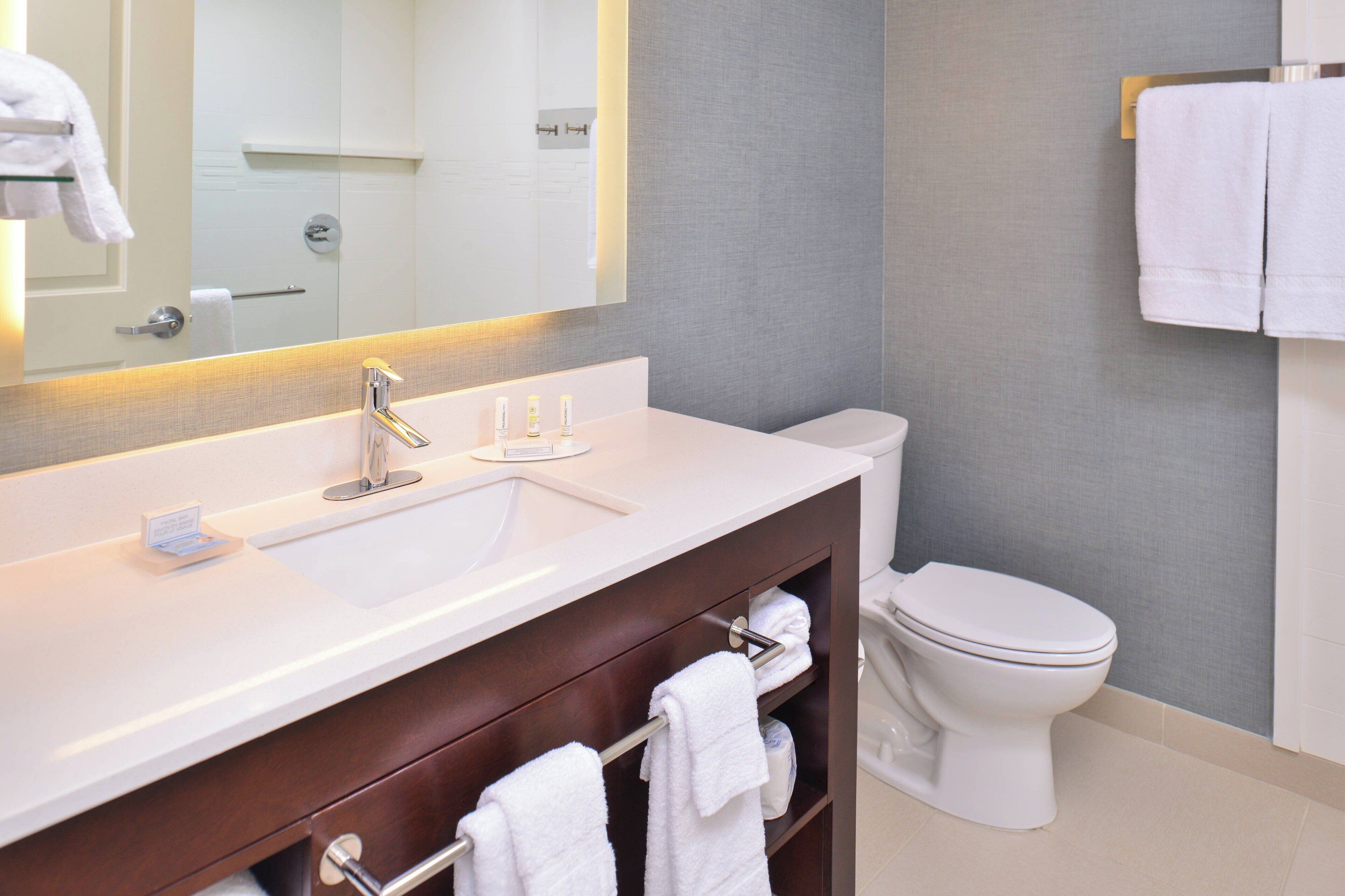 Une salle de bain moderne avec un lavabo, un meuble-lavabo et des toilettes, le tout de couleur blanche.