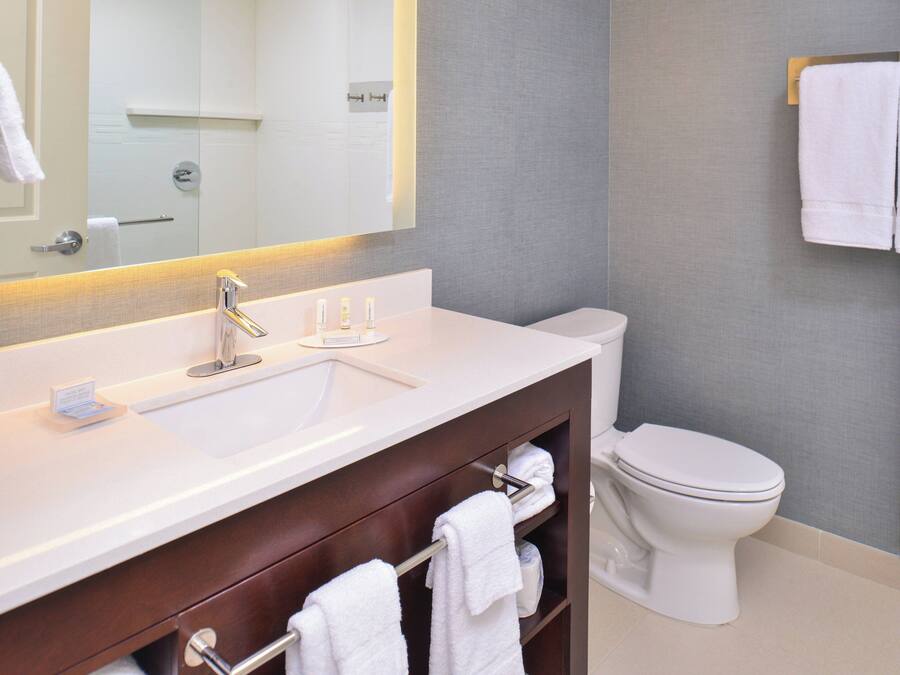 Une salle de bain moderne avec un lavabo, un meuble-lavabo et des toilettes, le tout de couleur blanche.