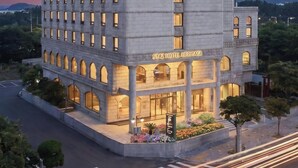 A multi-story hotel with a prominent entrance, large windows, and a sign reading 'STAZ HOTEL HERITAGE.' - Staz Hotel Heritage (Jeju City)