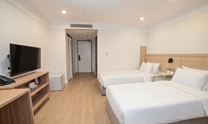 A hotel room with two beds, a TV, a desk, and a wardrobe. - Staz Hotel Heritage (Jeju City)