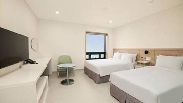 A hotel room with a bed, bedside table, chair, and a TV.
