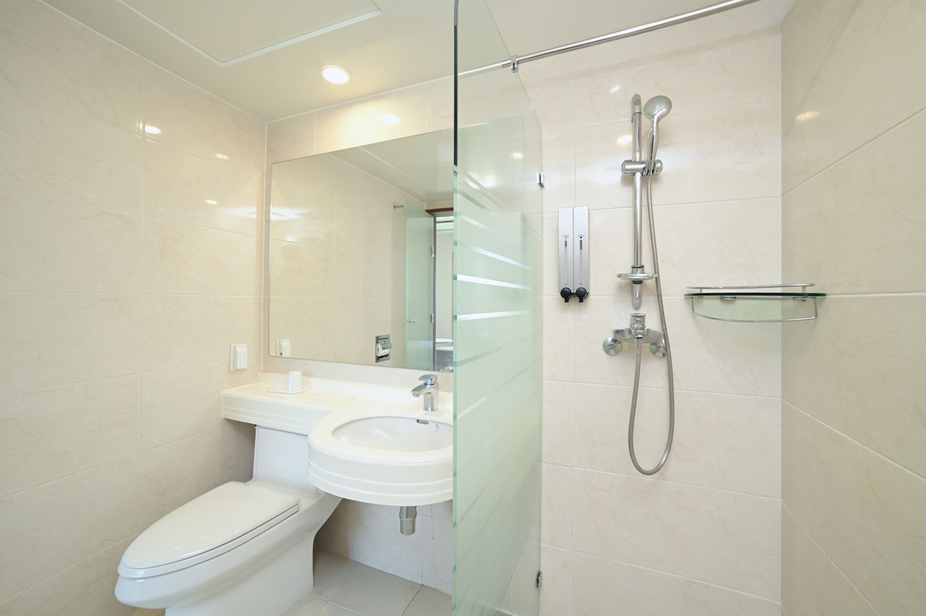 A modern bathroom with a toilet, sink, and glass shower enclosure.