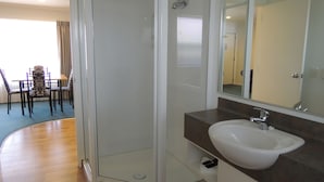 A modern bathroom with a white sink, dark countertop, and a large mirror. - Central Motor Lodge (Morrinsville)