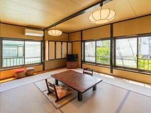 Een traditionele Japanse kamer met tatami vloerbedekking, een lage tafel en schuifdeuren.