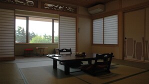 Ein traditioneller japanischer Raum mit Tatami-Böden, einem niedrigen Tisch und Schiebetüren.