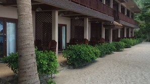 A multi-story hotel with balconies, a sandy beach in front, and tropical vegetation. - Haad Khuad Resort (Ko Pha-ngan)