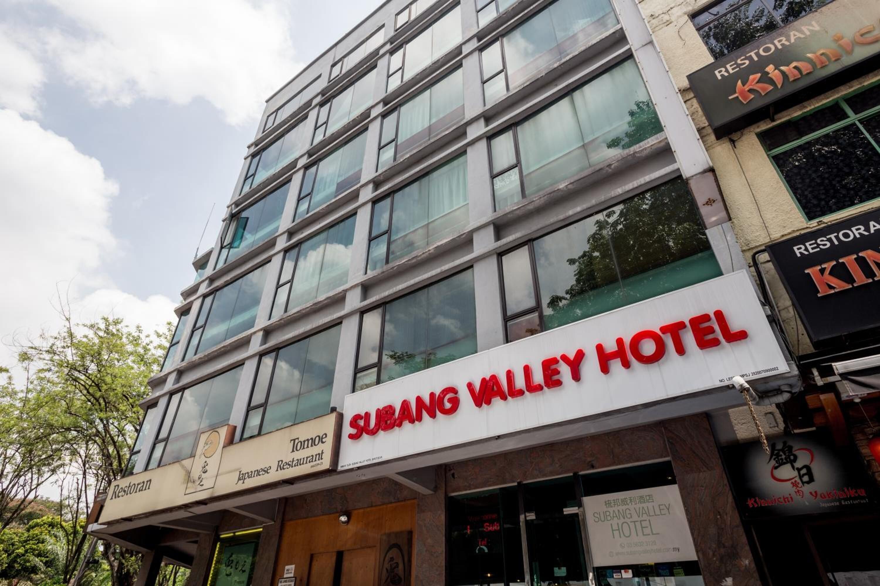A hotel with a modern facade, multiple floors, and large windows.