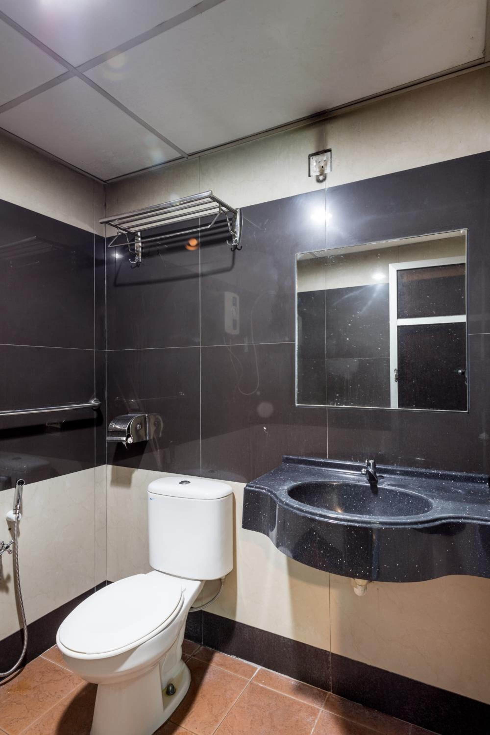 A bathroom with a toilet, sink, and towel rack.
