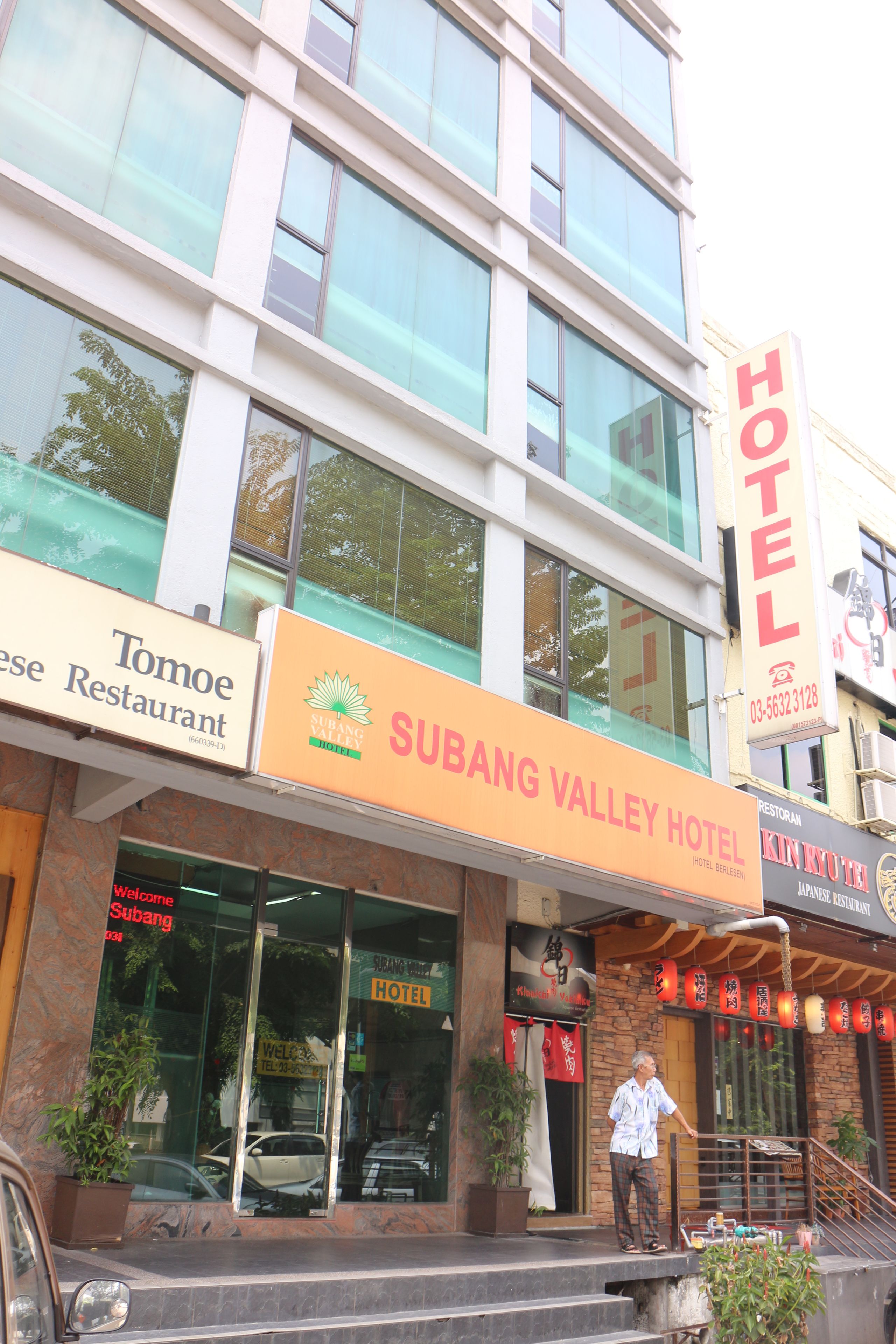 Een hotel met een bord waarop 'Subang Valley Hotel' staat en een restaurant genaamd Tomoe.