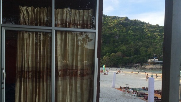 Vista a la playa desde un espacio techado con terraza de madera.