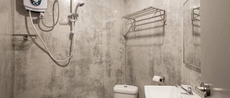 A bathroom with a shower, toilet, and sink.