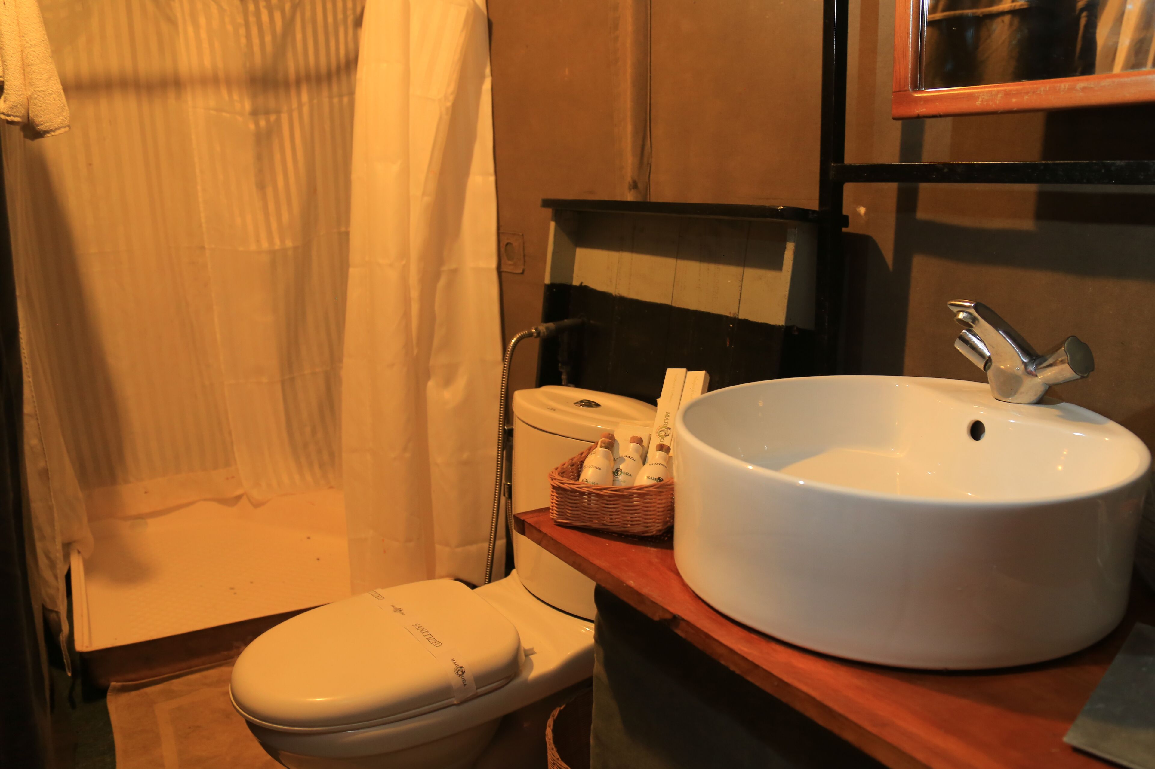 A bathroom with a white toilet, a white sink, and a shower curtain.