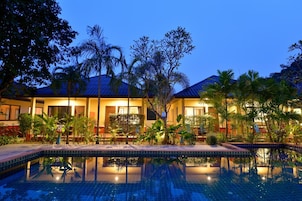 Una piscina al aire libre, sillones reclinables de piscina