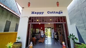 The entrance to Happy Cottage with a wooden facade and a sign above the door. - Happy Cottages Phuket (Chalong)