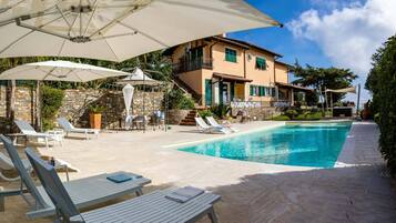 Piscine extérieure en saison, parasols, chaises longues