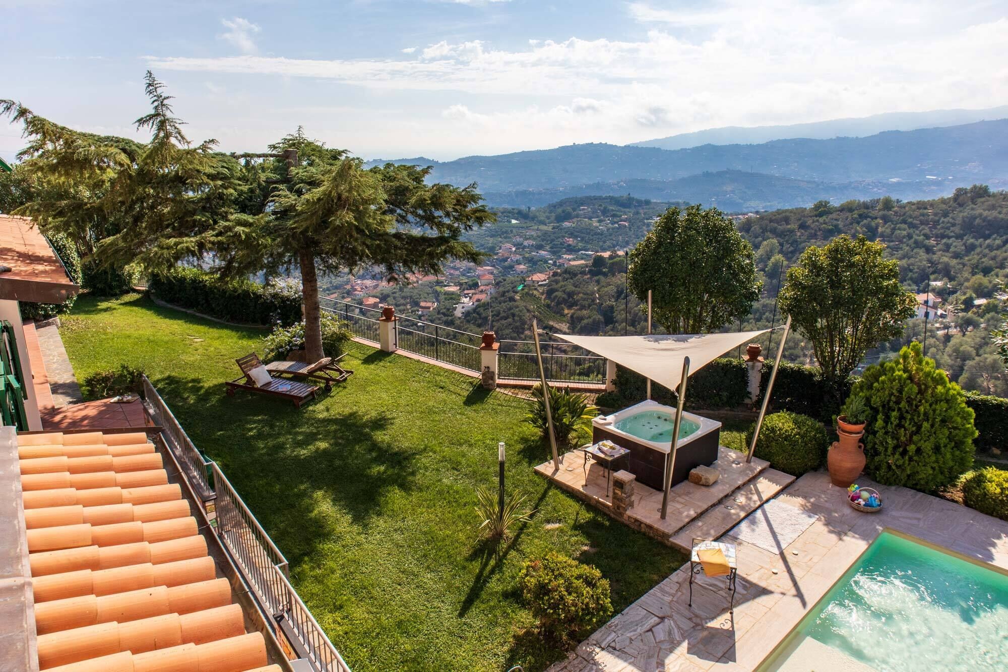 A rooftop terrace with a pool, a hot tub, and a view of a valley.