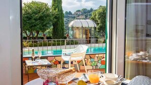 Una mesa de desayuno con vistas a una piscina y jardín.