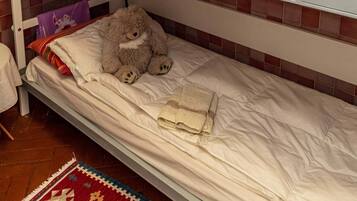 Ein Schlafraum mit Etagenbett, auf der unteren Etage ein Teddybär und auf der oberen Etage ein weißer Teddybär.